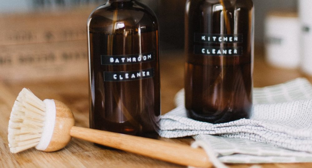 Bathrrom and Kitchen cleaner with wooden scrub brush and towels.