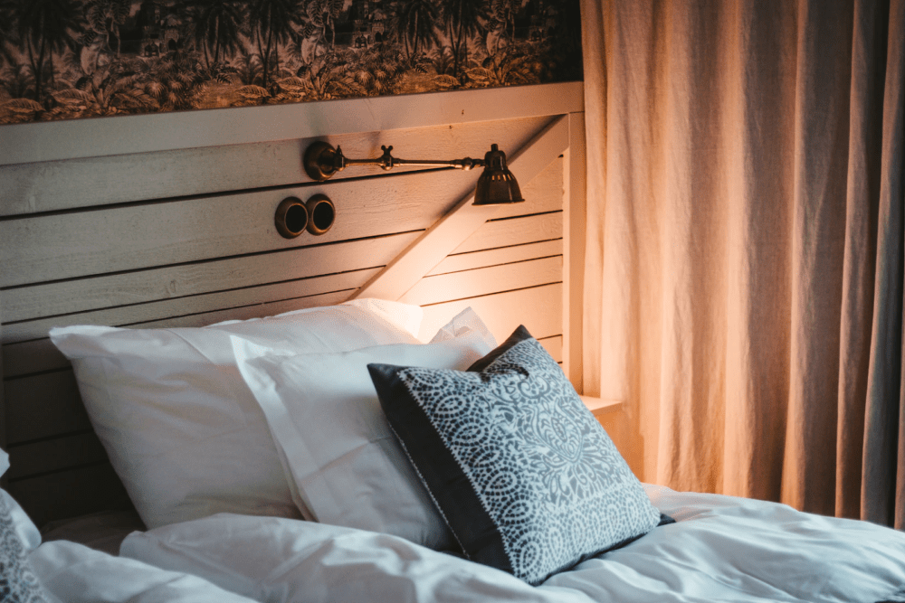bed with mood lighting via headboard sconce